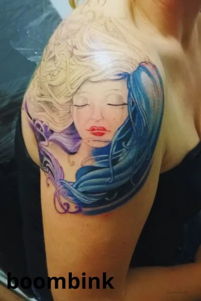 Tatuaje a color de mujer con cabello azul en el brazo.