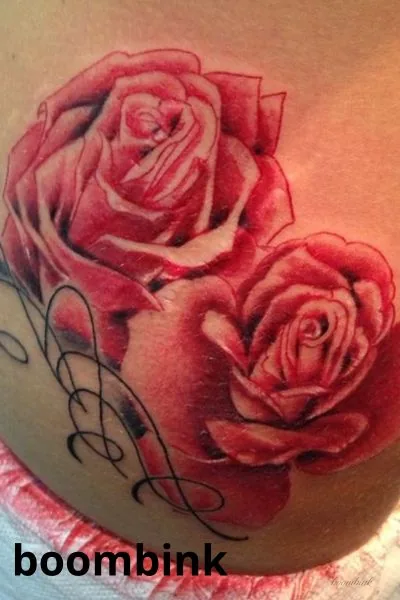 Tatuaje a color de rosas rojas en el brazo.