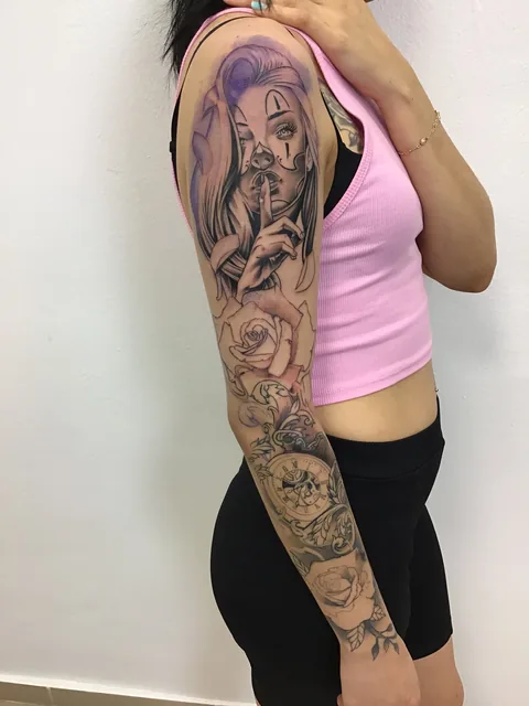 Tatuaje black and grey de una chicana con rosas en el brazo, vista frontal.