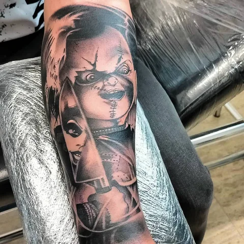 Tatuaje black and grey de Chucky y Tiffany en el antebrazo.