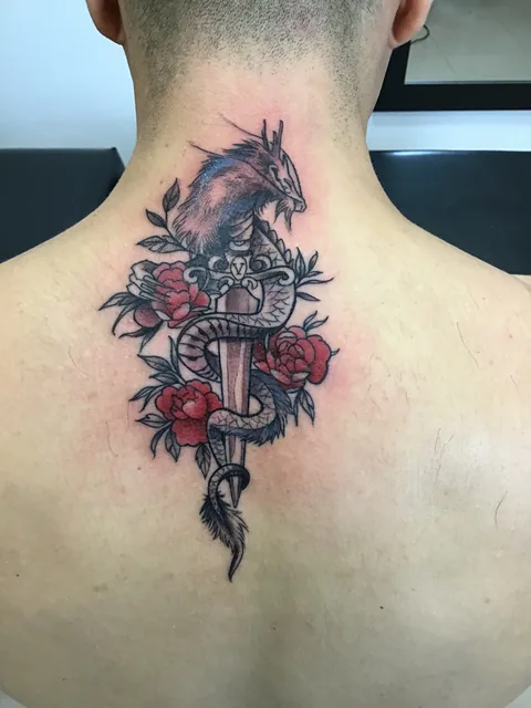 Tatuaje neotradicional de daga serpiente y rosas en la espalda.
