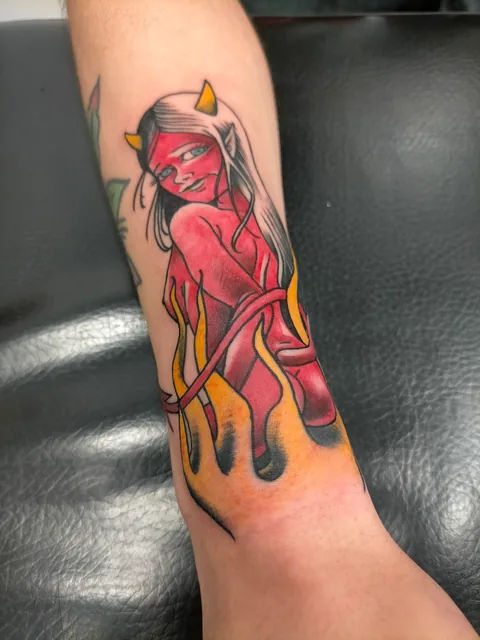 Tatuaje neotradicional de una diablesa roja en el antebrazo.