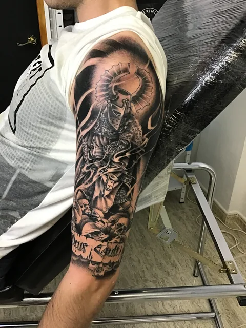 Tatuaje black and grey de un guerrero en el brazo.