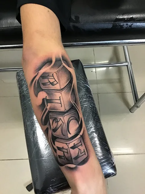 Tatuaje lettering en black and grey en el antebrazo.