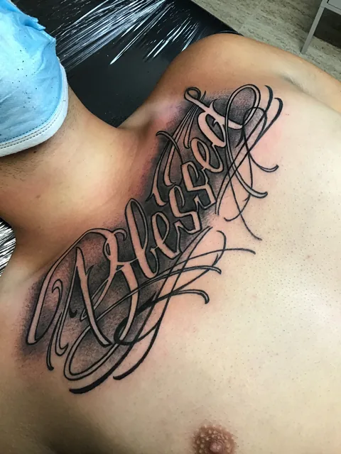 Tatuaje lettering de caligrafía ornamental en el pecho.