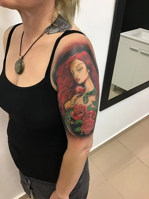 Tatuaje neotradicional de una mujer pelirroja con rosas en el brazo.