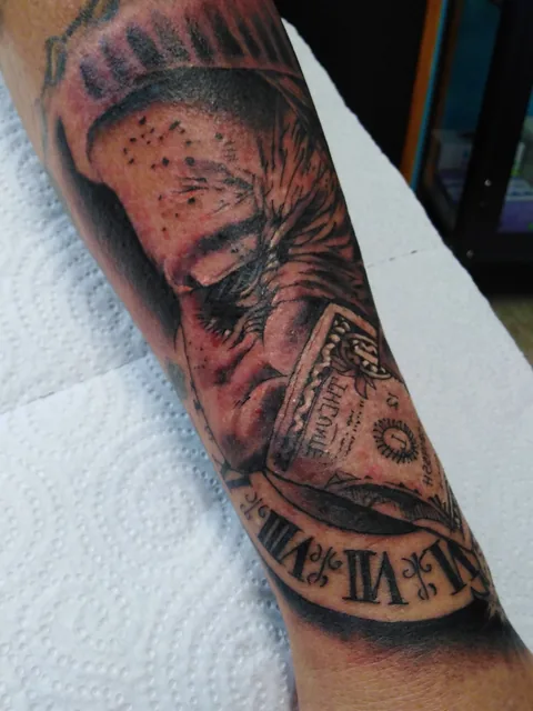 Tatuaje black and grey de un ojo y un reloj en el antebrazo.