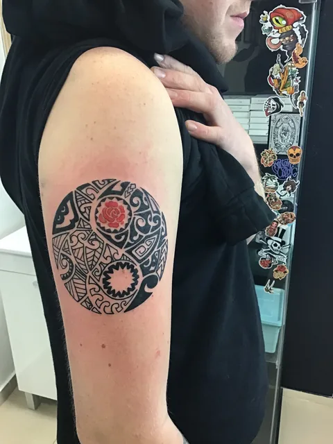 Tatuaje ornamental circular blackwork en el brazo.