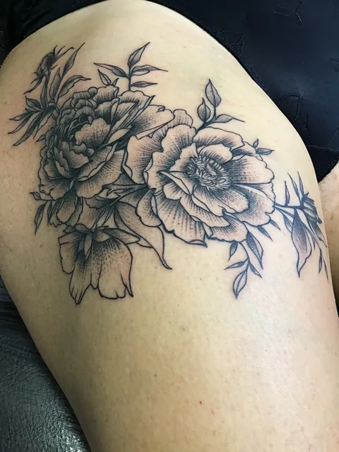 Tatuaje black and grey de peonías en el hombro.