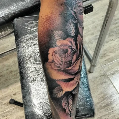 Tatuaje black and grey de una rosa en el antebrazo.