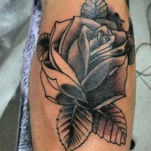 Tatuaje black and grey de una rosa en el brazo.
